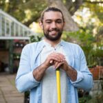 Portrait of happy gardener with work tool at garden