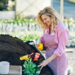 Woman transplanting pot plants while working in a greenhouse